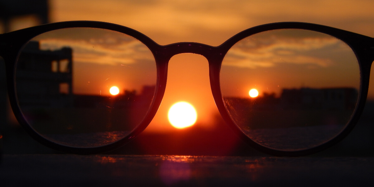 Round Sunglasses resting on a grey wall